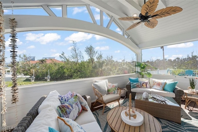 sunroom with ceiling fan, vaulted ceiling, and a wealth of natural light