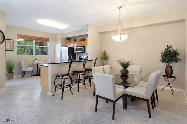 dining area featuring light tile patterned floors and sink