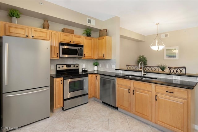 kitchen featuring pendant lighting, stainless steel appliances, sink, and decorative backsplash