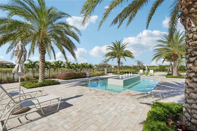 view of swimming pool with a hot tub and a patio area