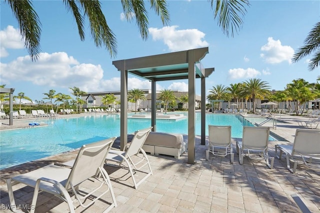 view of swimming pool with a hot tub and a patio