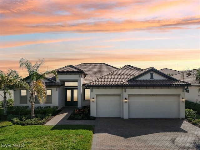 view of front of house featuring a garage and a lawn