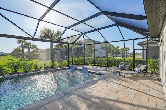 view of pool with a patio area and glass enclosure