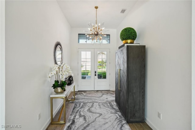 entryway with an inviting chandelier, wood-type flooring, french doors, and vaulted ceiling