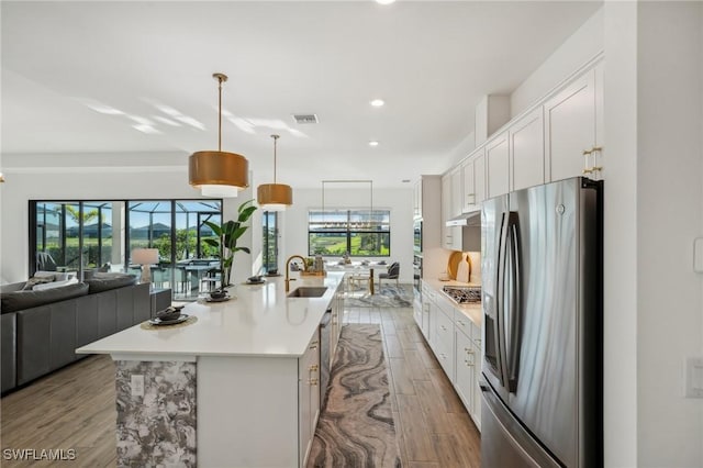 kitchen featuring white cabinetry, an island with sink, and appliances with stainless steel finishes