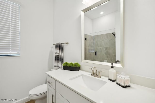 bathroom with a shower with door, vanity, and toilet