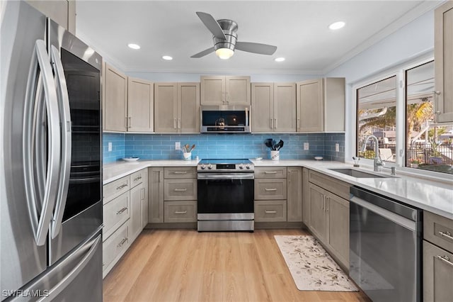 kitchen featuring sink, decorative backsplash, light hardwood / wood-style floors, stainless steel appliances, and crown molding