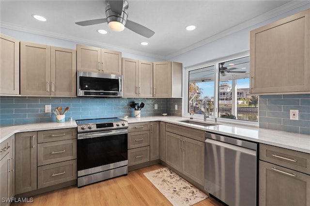 kitchen featuring sink, crown molding, tasteful backsplash, light hardwood / wood-style flooring, and stainless steel appliances