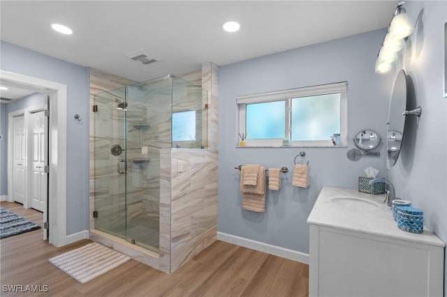 bathroom with hardwood / wood-style flooring, vanity, and an enclosed shower