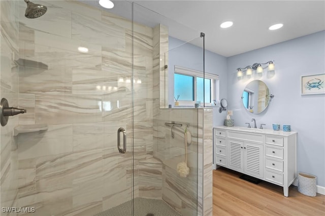 bathroom featuring walk in shower, wood-type flooring, and vanity