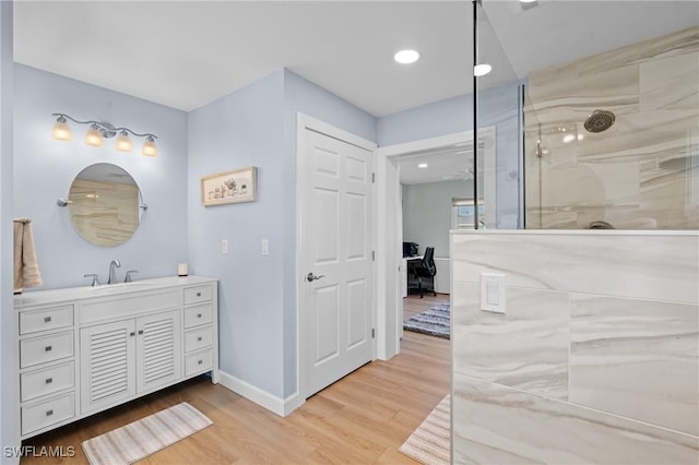 bathroom featuring vanity, hardwood / wood-style flooring, and tiled shower