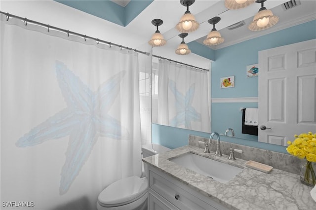 bathroom with ornamental molding, vanity, and toilet