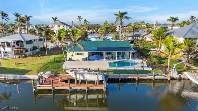 rear view of property featuring a water view and a yard