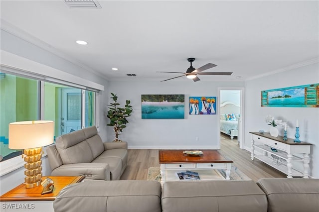 living room featuring ornamental molding, ceiling fan, and light wood-type flooring