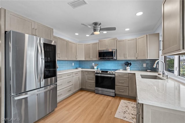 kitchen featuring sink, light hardwood / wood-style flooring, ornamental molding, stainless steel appliances, and decorative backsplash