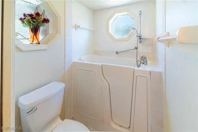 bathroom with a washtub and toilet