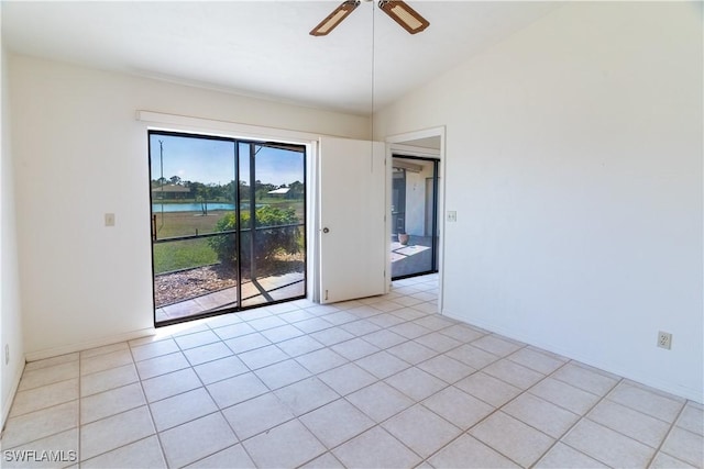 unfurnished room featuring a water view, light tile patterned floors, lofted ceiling, and ceiling fan