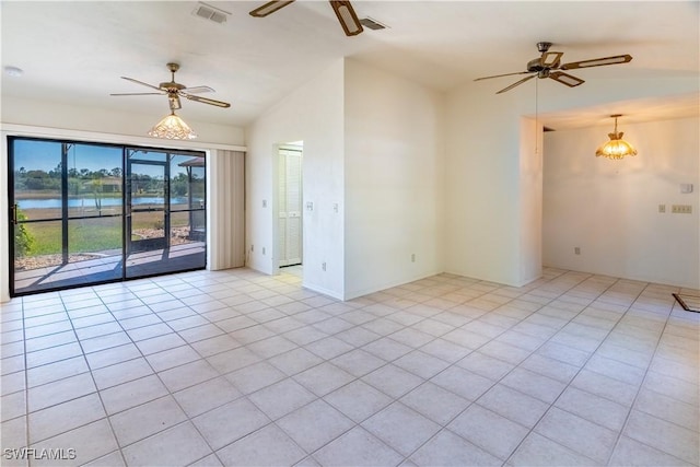 unfurnished room with a water view, light tile patterned floors, lofted ceiling, and ceiling fan