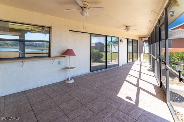 unfurnished sunroom featuring ceiling fan