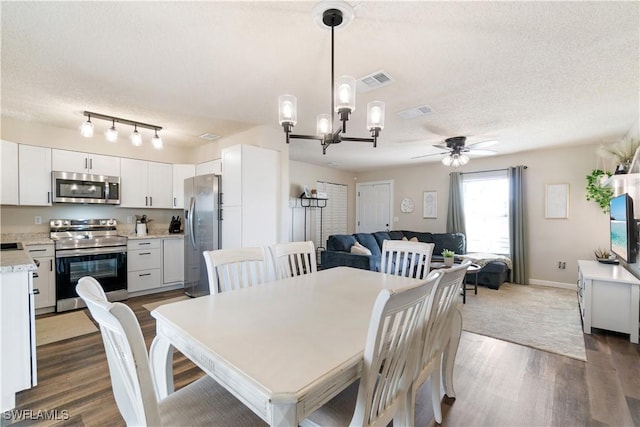 dining space featuring dark hardwood / wood-style flooring, sink, ceiling fan with notable chandelier, and a textured ceiling