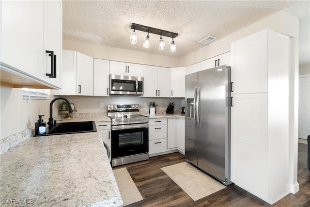 kitchen with white cabinetry, sink, dark hardwood / wood-style flooring, stainless steel appliances, and a textured ceiling