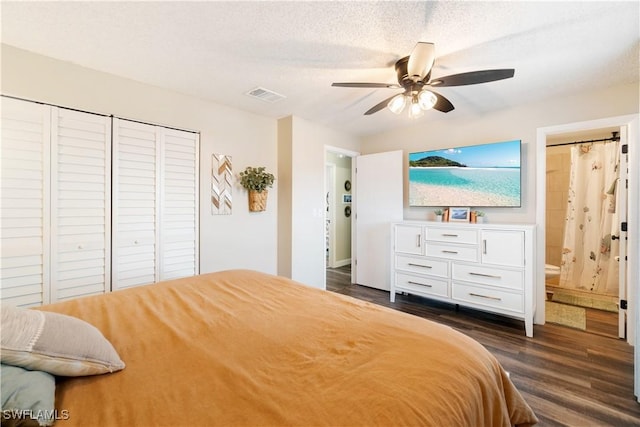 bedroom with ceiling fan, a textured ceiling, dark hardwood / wood-style flooring, and ensuite bath