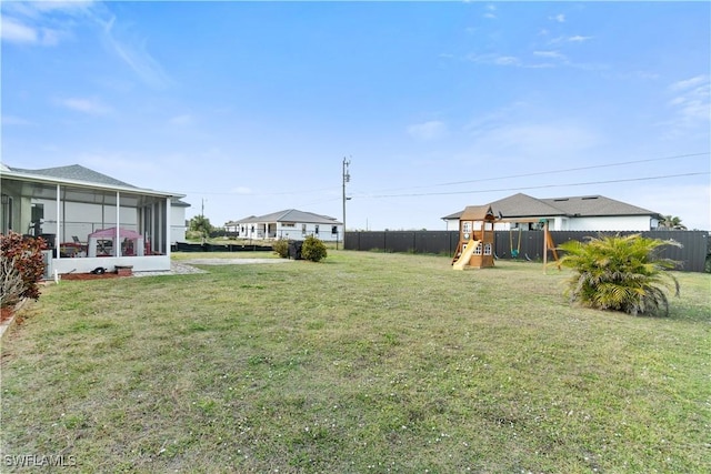 view of yard featuring a playground and a sunroom