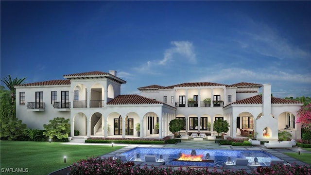 rear view of house with a balcony, a yard, and a patio