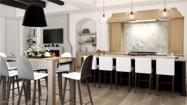 kitchen featuring light hardwood / wood-style flooring, a kitchen bar, light brown cabinetry, decorative backsplash, and decorative light fixtures