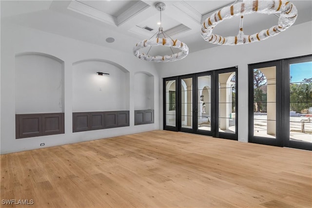 unfurnished room with an inviting chandelier, hardwood / wood-style flooring, coffered ceiling, and french doors