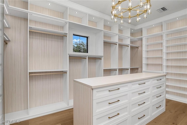 50 Mahogany Dr, Naples, FL 34108 - spacious closet with visible vents, wood finished floors, and an inviting chandelier