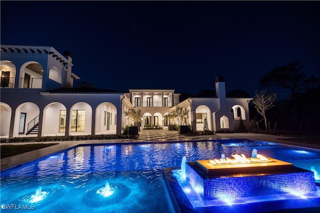 50 Mahogany Dr, Naples, FL 34108 - pool at night featuring a community hot tub, a community pool, and a patio area