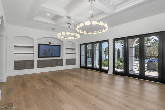 50 Mahogany Dr, Naples, FL 34108 - unfurnished living room with beamed ceiling, built in shelves, a notable chandelier, coffered ceiling, and french doors