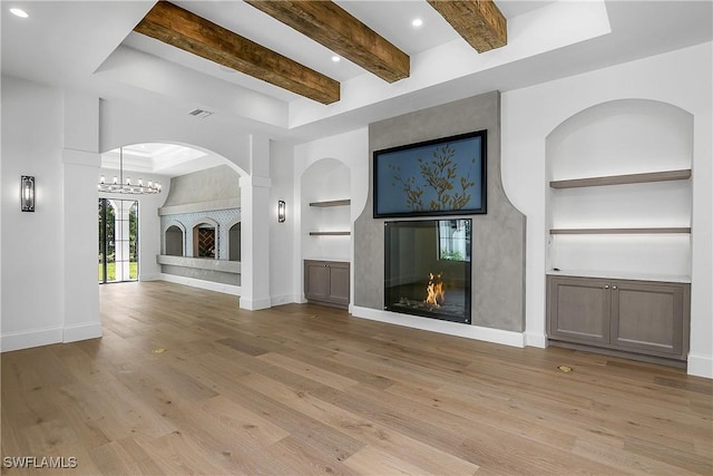 50 Mahogany Dr, Naples, FL 34108 - unfurnished living room featuring built in features, a fireplace, baseboards, light wood-type flooring, and beam ceiling