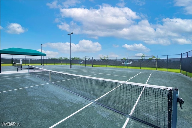 view of tennis court featuring fence