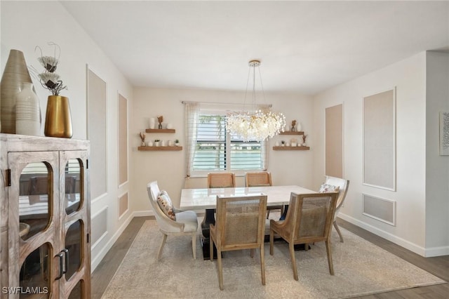 dining area with a chandelier, baseboards, and wood finished floors