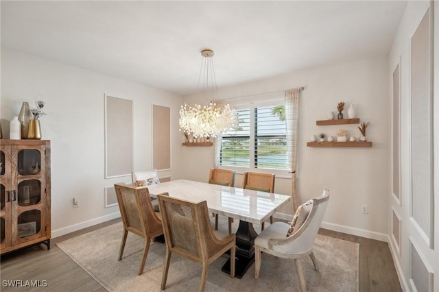 dining space with light wood finished floors, baseboards, and a notable chandelier