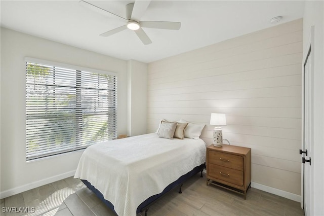 bedroom featuring wood finished floors, a ceiling fan, and baseboards