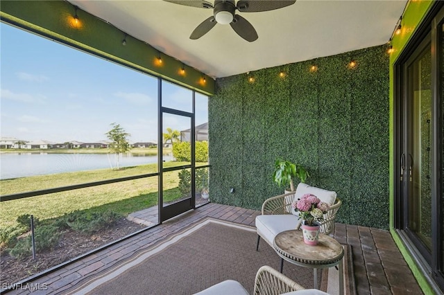 unfurnished sunroom with a water view and a ceiling fan