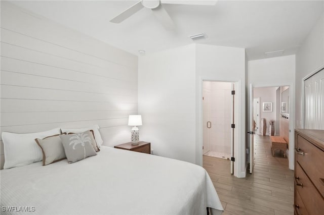 bedroom featuring ensuite bathroom, light wood-style flooring, visible vents, and a ceiling fan