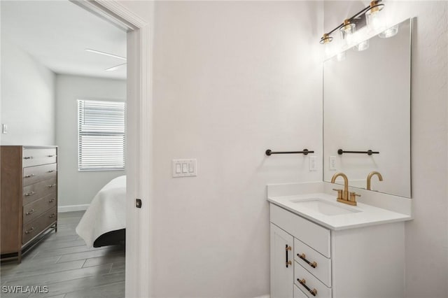 bathroom with vanity, baseboards, and wood finished floors