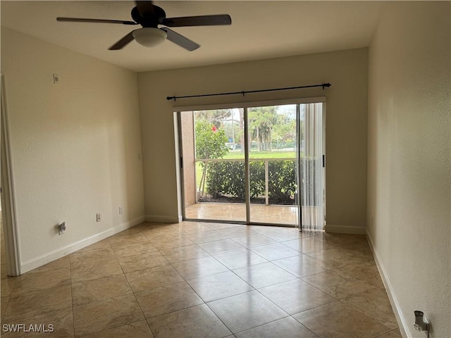 tiled empty room featuring baseboards and a ceiling fan