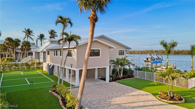 view of front of house with a front yard and a water view