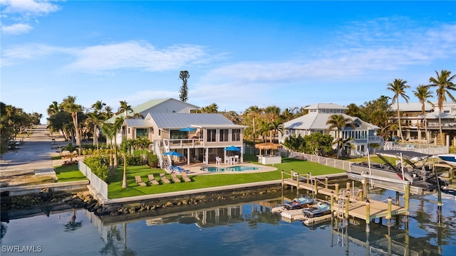 rear view of house with a yard, a patio area, and a water view