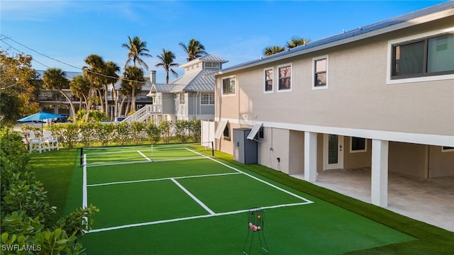 view of sport court with a patio area