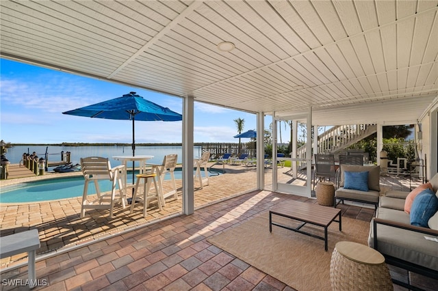 view of patio featuring outdoor lounge area, stairs, an outdoor pool, and a water view