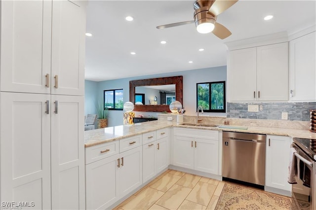 kitchen with tasteful backsplash, stainless steel appliances, sink, and white cabinets