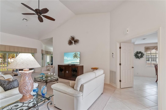 living room with ceiling fan, high vaulted ceiling, and light tile patterned floors