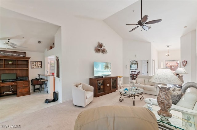 carpeted living room with high vaulted ceiling, built in desk, and ceiling fan with notable chandelier