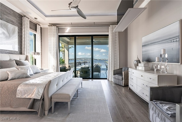 bedroom with multiple windows, access to exterior, ceiling fan, and dark hardwood / wood-style flooring